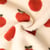 Tissu Fausse fourrure Mouton Romy pommes Rouges sur fond Ecru